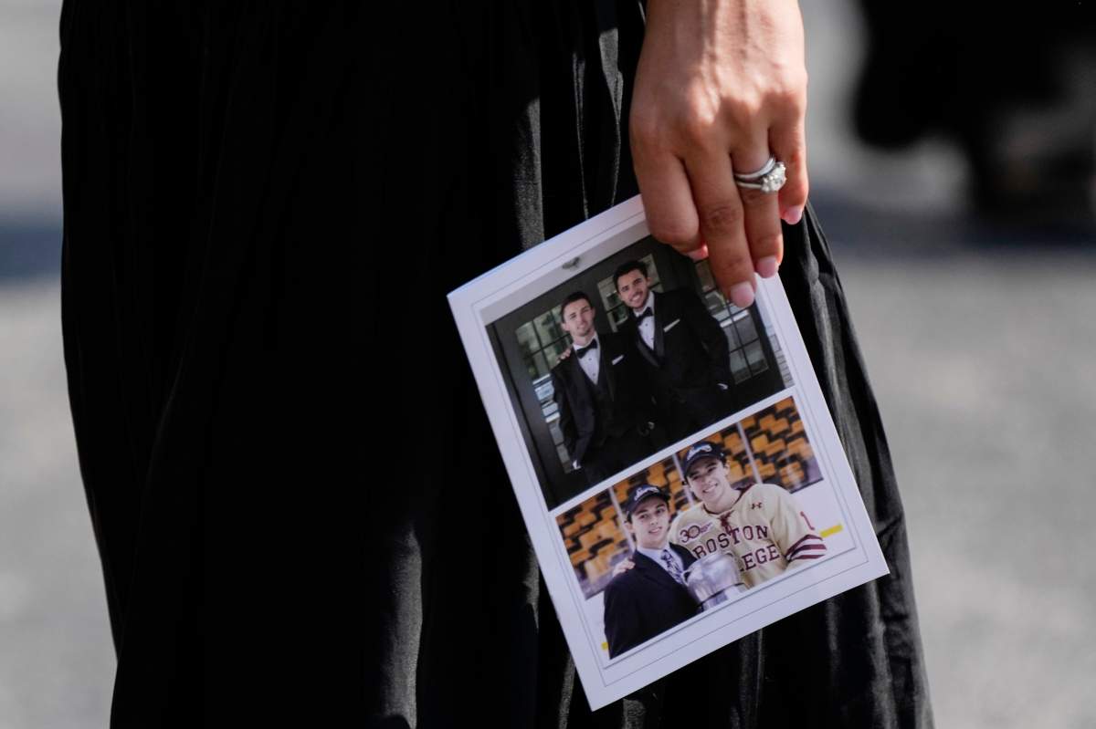 A mourner departs while holding a program following the funeral for Columbus Blue Jackets hockey player John Gaudreau and his brother Matthew Gaudreau at St. Mary Magdalen Catholic Church in Media, Pa., Monday, Sept. 9, 2024.