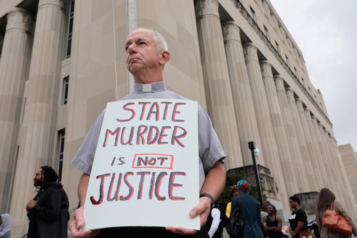 Deacon Dave Billips, with the Office of Peace and Justice with the St. Louis Archdiocese, holds a sign as he stands with protesters holding space to halt the execution of Marcellus Williams on Tuesday, Sept. 24, 2024, outside the Carnahan Courthouse in St. Louis.