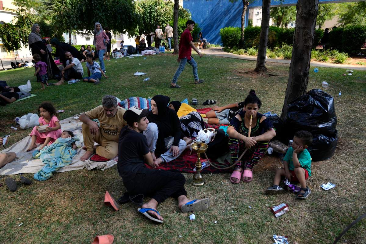 People who fled the southern suburb of Beirut amid ongoing Israeli airstrikes, sit at a park in down town Beirut, Lebanon, Saturday, Sept. 28, 2024.