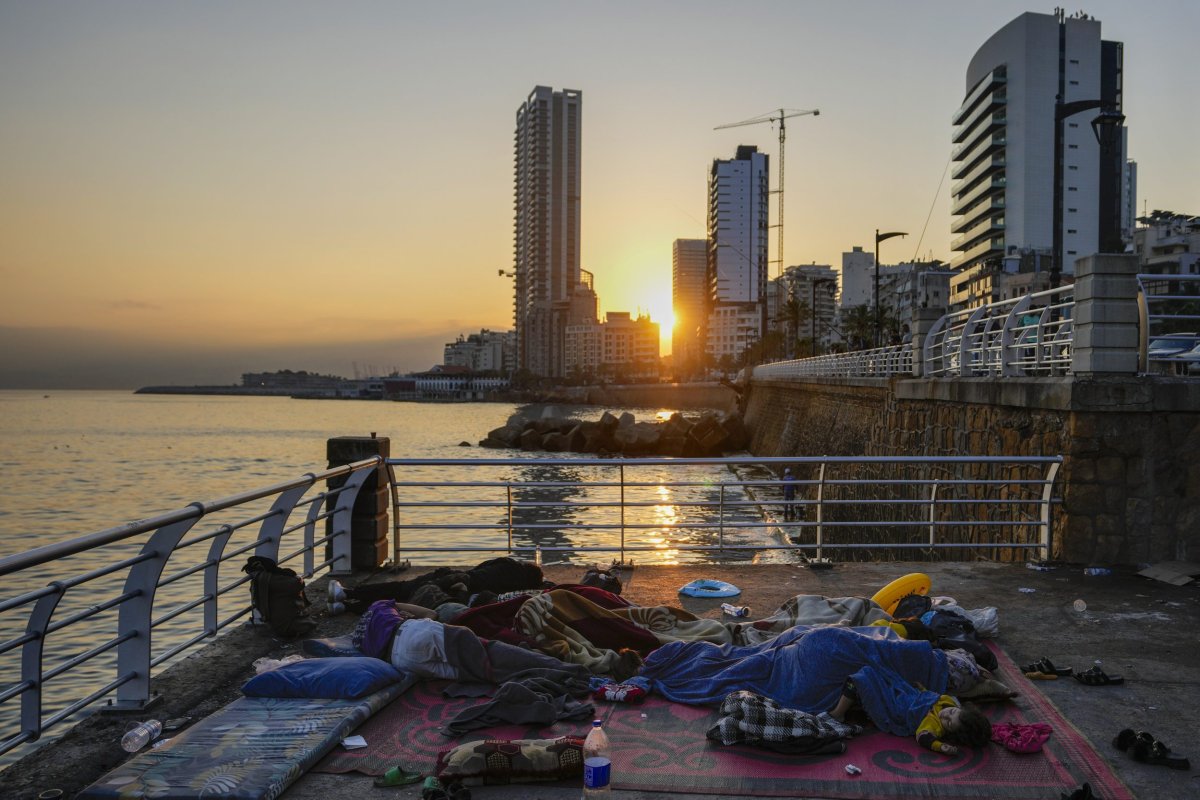 Families sleep on Beirut’s corniche after fleeing the Israeli airstrikes in Beirut’s southern suburb, Lebanon, Monday, Sept. 30, 2024. (AP Photo/Hassan Ammar)