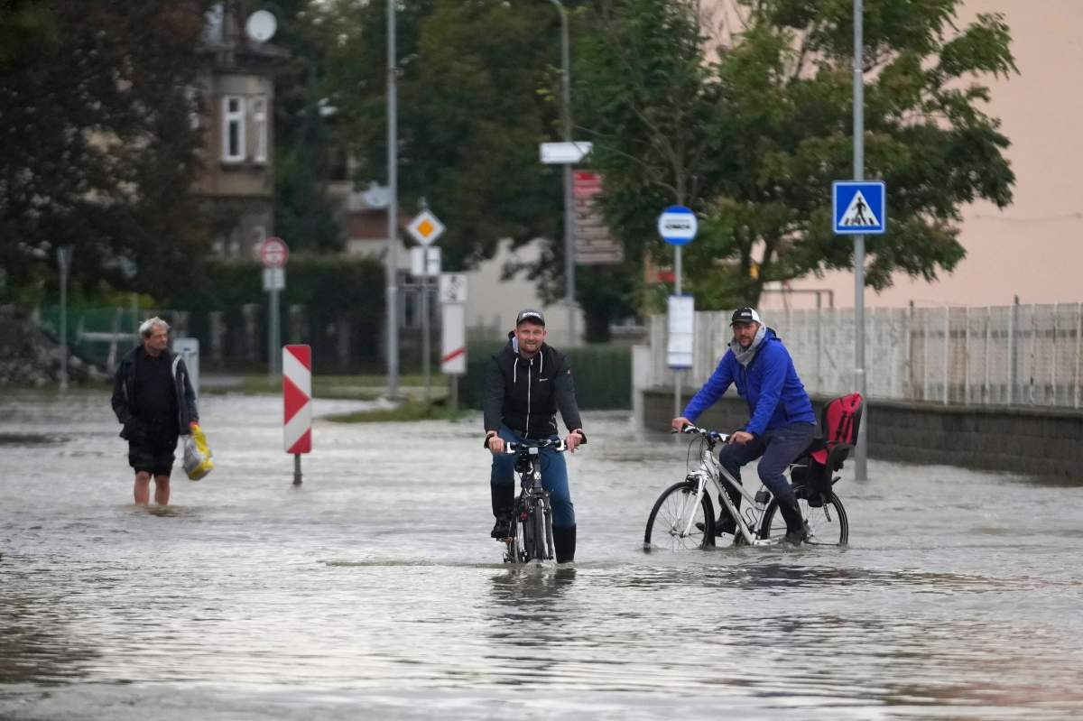Residents ride bicycles through a flooded street in Litovel, Czech Republic, on Monday. (AP Photo/Petr David Josek)