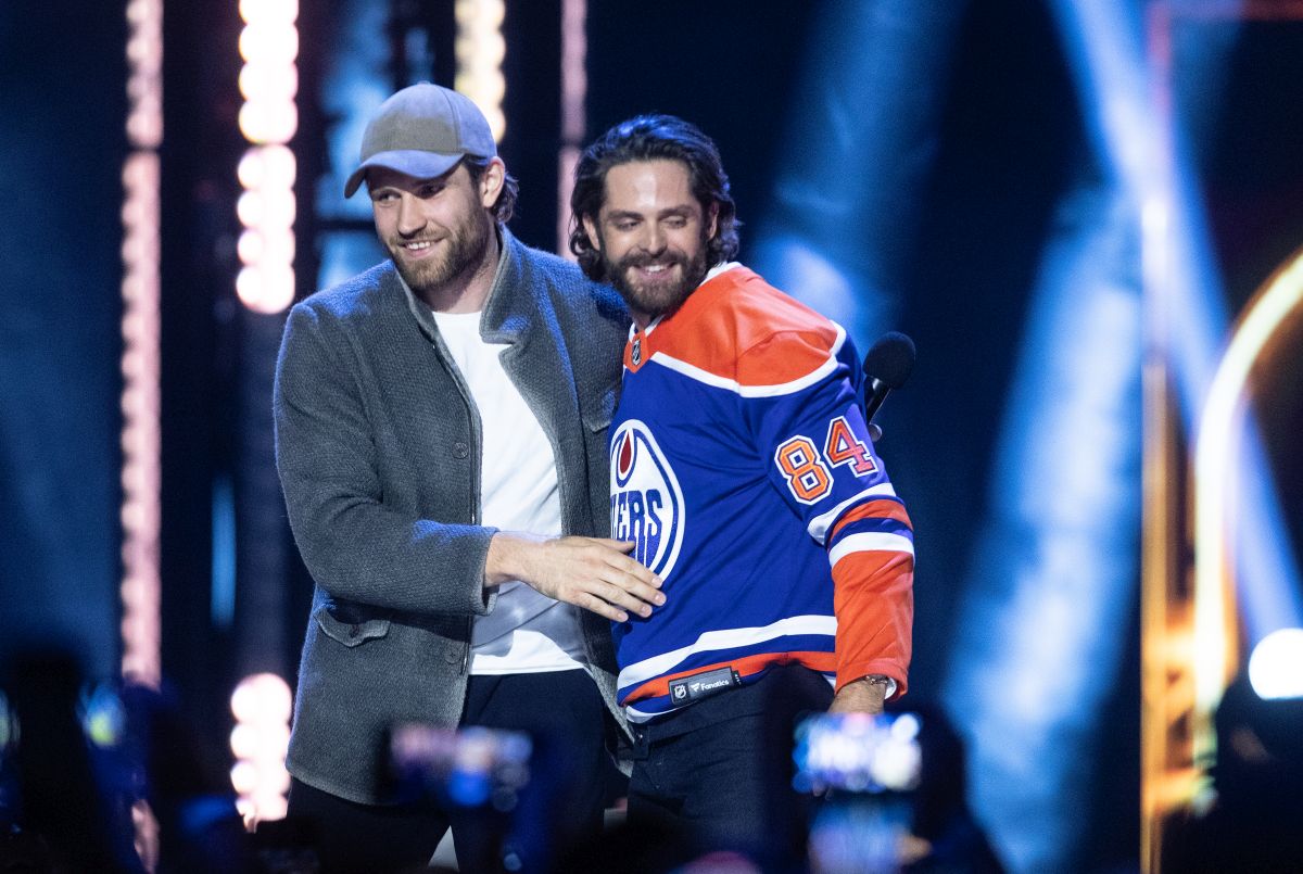 Edmonton Oilers' Leon Draisaitl, left, gives a jersey to host Thomas Rhett during the CCMA Awards in Edmonton on Saturday, September 14, 2024.