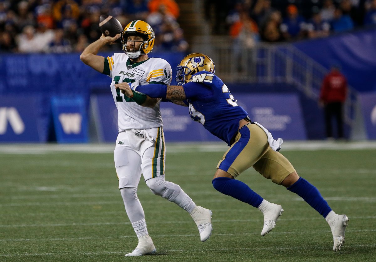 Winnipeg Blue Bombers' Tony Jones (33) gets his hands on Edmonton Elks quarterback McLeod Bethel-Thompson (10) during second half CFL action in Winnipeg Friday, September 27, 2024.