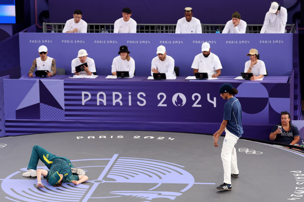 B-Girl Raygun of Team Australia competes as Syssy of Team France looks on during the B-Girls Round Robin - Group B on day fourteen of the Olympic Games Paris 2024 at Place de la Concorde on August 9, 2024 in Paris, France.