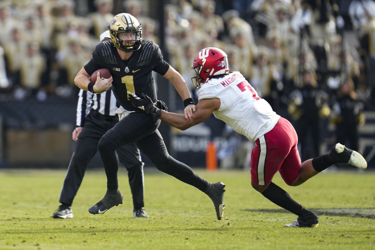 Purdue quarterback Hudson Card (1) escapes from Indiana linebacker Jacob Mangum-Farrar (7) during the second half of an NCAA college football game in West Lafayette, Ind., Saturday, Nov. 25, 2023. Purdue defeated Indiana 35-31.