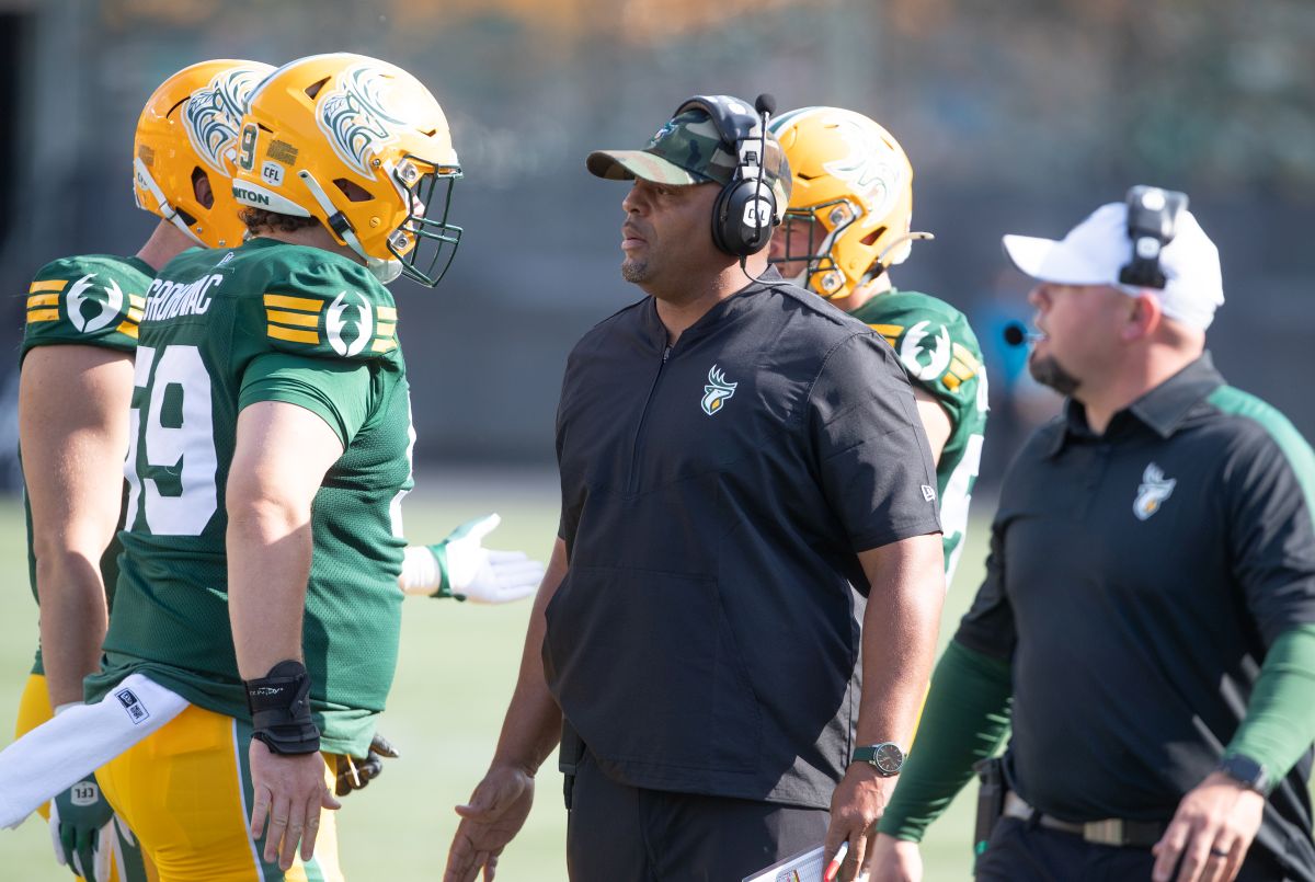 Edmonton Elks intern coach Jarious Jackson talks with Phillip Grohovac (59) while taking on the Hamilton Tiger-Cats during first half CFL action in Edmonton, Sunday, July 28, 2024.