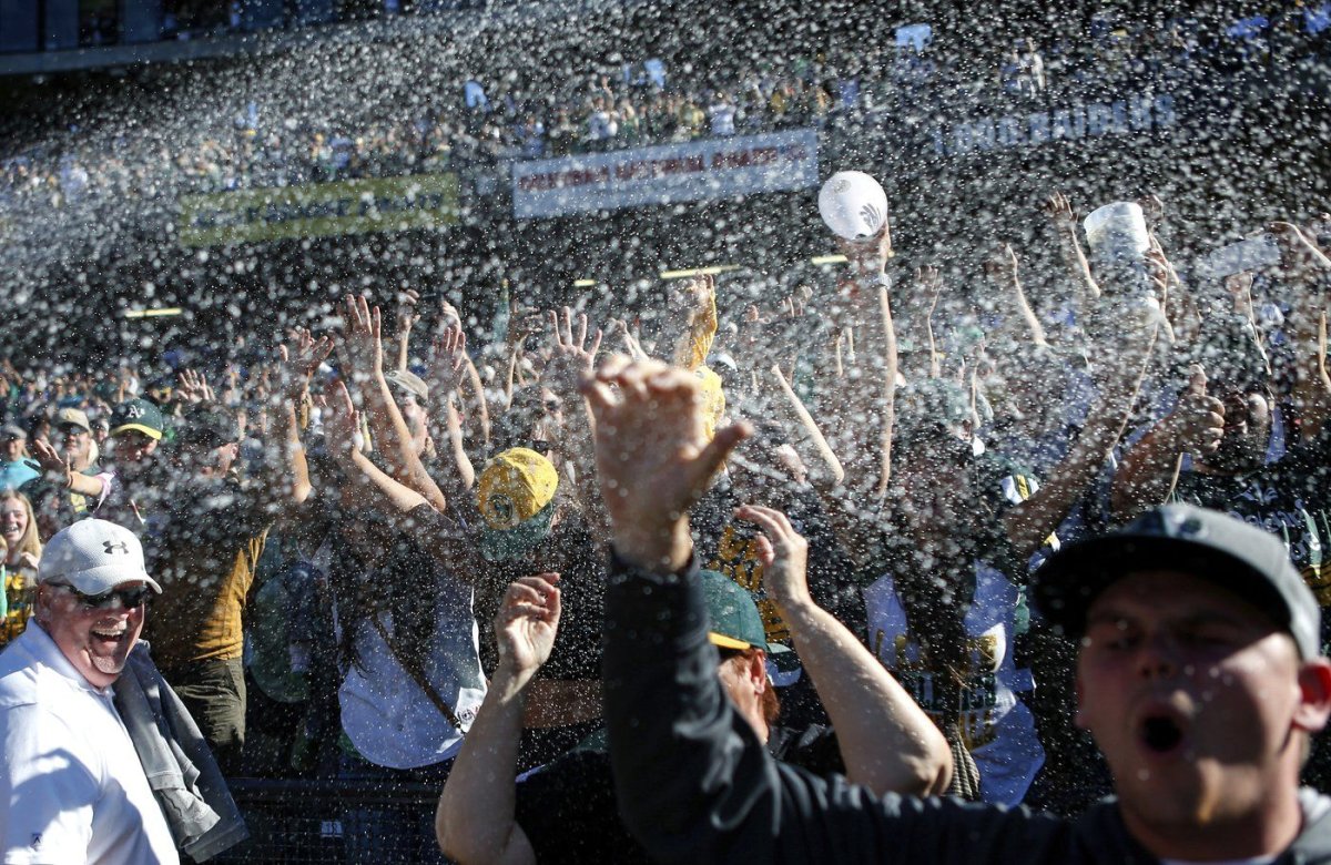 FILE - Oakland Athletics fans celebrate after the Athletics defeated the Minnesota Twins in a baseball game to become American League West champions, Sept. 22, 2013, in Oakland, Calif.