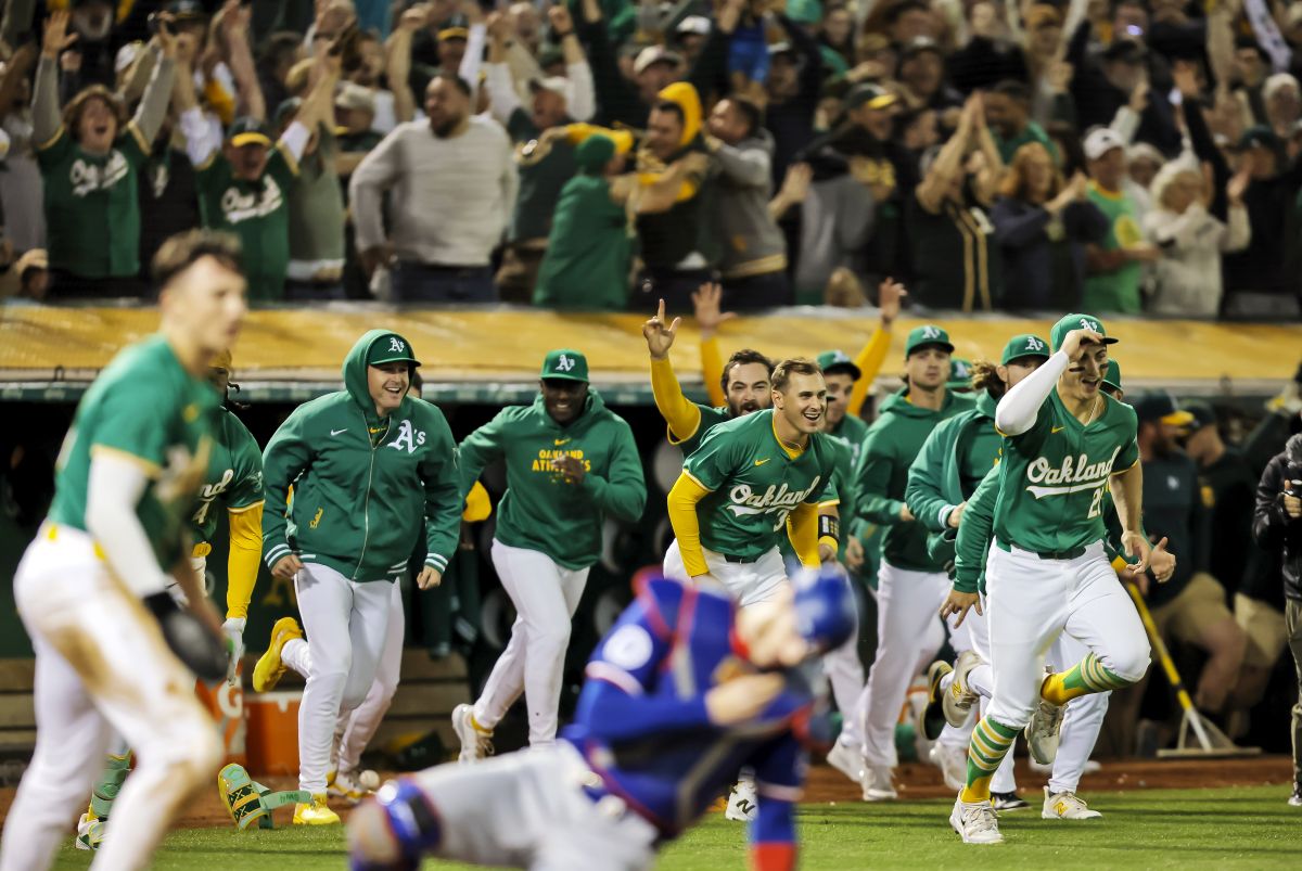 Oakland Athletics players pour out of the dugout to celebrate after defeating the Texas Rangers 5-4 on a walk-off RBI single by Jacob Wilson in the ninth inning of a baseball game at the Coliseum in Oakland, Calif., on Tuesday, Sept. 24, 2024.