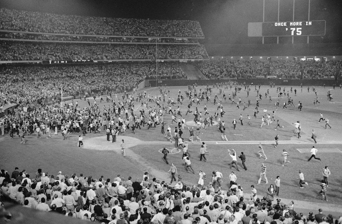 FILE - Fans pour onto the field at the Oakland Coliseum after the Oakland A's beat the Los Angeles Dodgers 3-2 and won their third straight World Series, Oct. 17, 1974, in Oakland