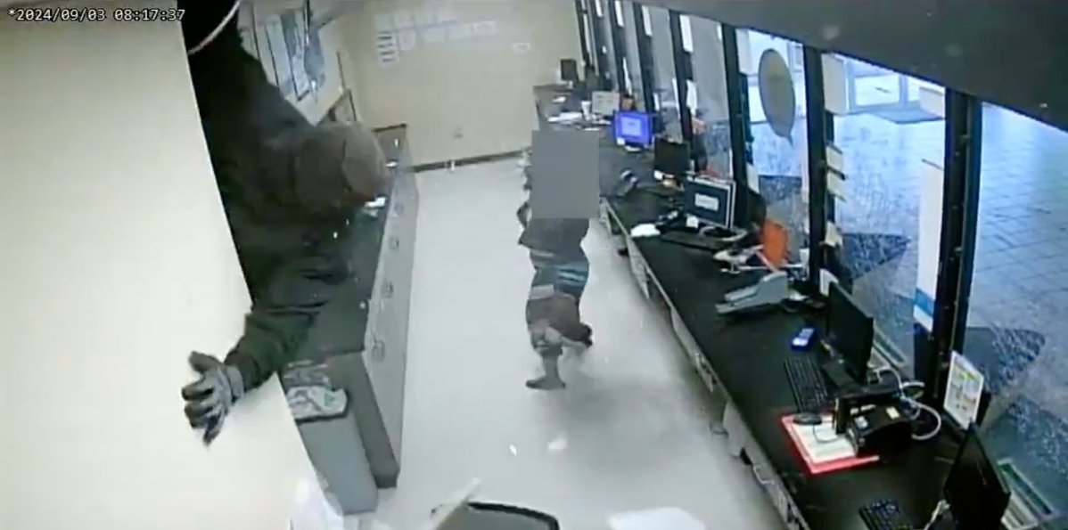 Screengrab of video provided by the Atlanta Police Department showing a masked robber crashing through the ceiling of a cheque-cashing store.