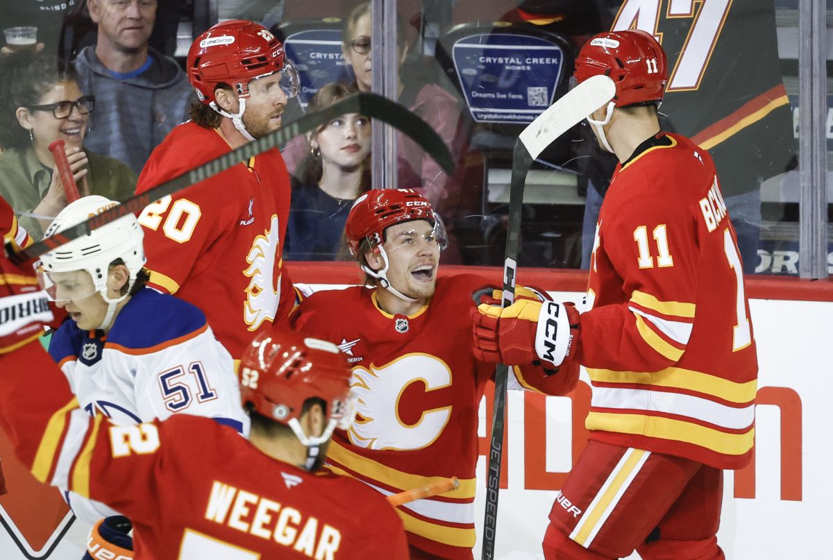 Calgary Flames' Connor Zary, centre, celebrates his goal with teammates Blake Coleman (20) and Mikael Backlund (11) during second period NHL preseason hockey action against the Edmonton Oilers in Calgary, Monday, Sept. 23, 2024.