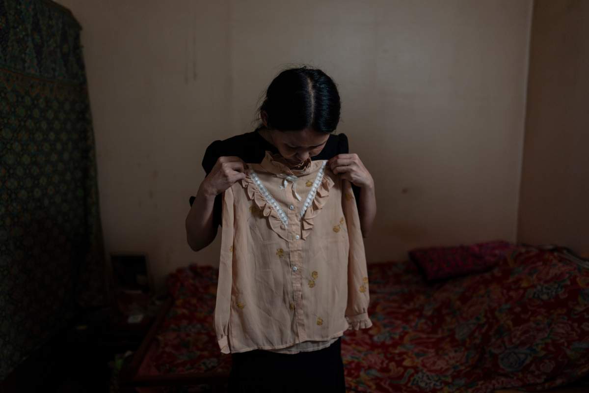 Yooree Kim holds up a blouse given to her by the adoption agency that sent her to France when she was 11 years old, at her apartment in Seoul, South Korea, Saturday, May 18, 2024. (AP Photo/Jae C. Hong)