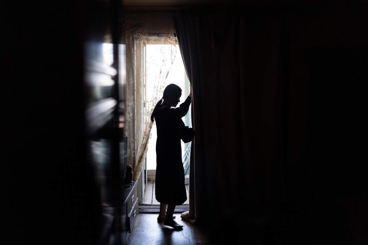 Yooree Kim, who was 11 when she was sent by the Korean adoption agency Holt Children’s Services to a couple in France, opens the curtain in her apartment in Seoul, South Korea, Saturday, May 18, 2024. (AP Photo/Jae C. Hong)