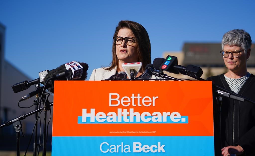 Saskatchewan NDP leader Carla Beck, middle, speaks as Nadine Baker, right, looks on during an announcement about investment in health care in Regina, Oct. 8, 2024. The Saskatchewan NDP appears to be continuing its focus on health-care issues during the provincial election campaign, with party candidates set to hold press conferences today outside hospitals in three communities. THE CANADIAN PRESS/Heywood Yu.