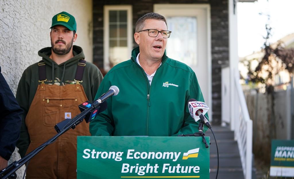 Saskatchewan Party Leader Scott Moe, middle, speaks during a media event in Regina, on Friday, October 4, 2024. THE CANADIAN PRESS/Heywood Yu