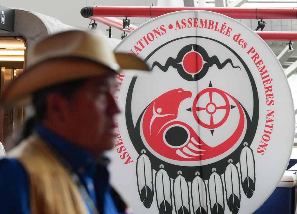 First Nations chiefs are gathered in Calgary today as they prepare to vote on a landmark $47.8-billion child welfare reform agreement with Ottawa.An attendee walks past a banner at the Assembly of First Nations annual general assembly in Montreal, Tuesday, July 9, 2024. THE CANADIAN PRESS/Christinne Muschi.