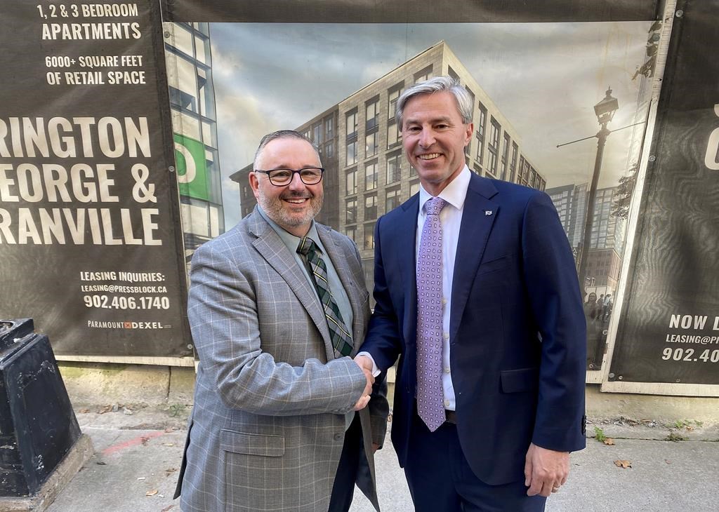 Former Nova Scotia Liberal MLA Fred Tilley, left, shakes the hand of Nova Scotia Premier Tim Houston outside the provincial legislature, in Halifax, Tuesday, Oct. 22, 2024. Houston announced that Tilley has crossed the floor to join the governing Tories. THE CANADIAN PRESS/Keith Doucette.