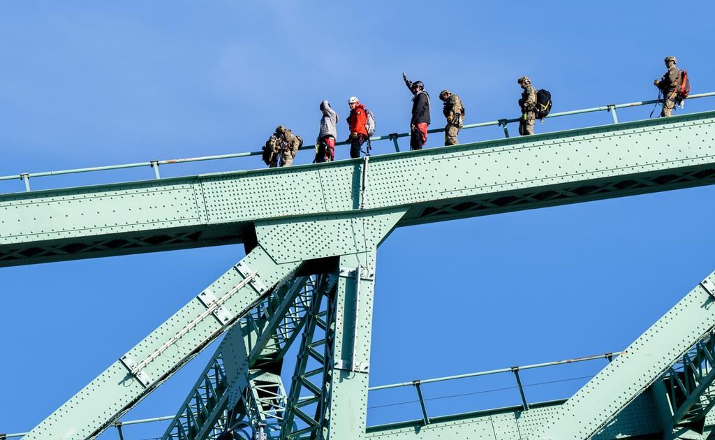 A pair of protesters are removed from the Jacques Cartier Bridge by first responders, in Montreal, Tuesday, Oct. 22, 2024.