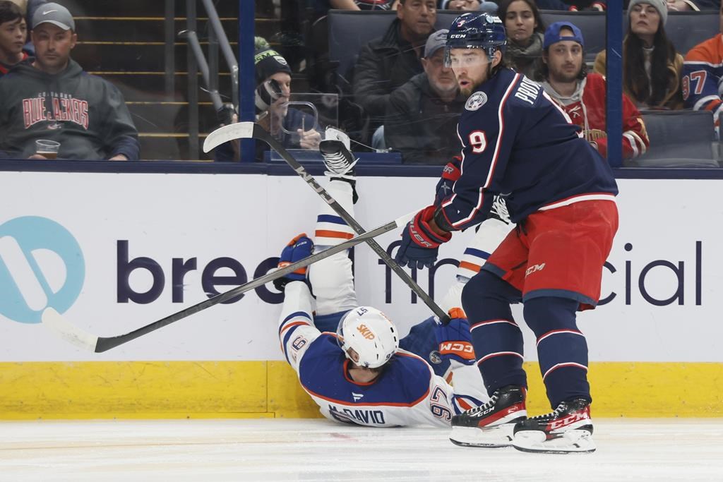 Columbus Blue Jackets' Ivan Provorov, right, knocks Edmonton Oilers' Connor McDavid to the ice during the first period of an NHL hockey game Monday, Oct. 28, 2024, in Columbus, Ohio.