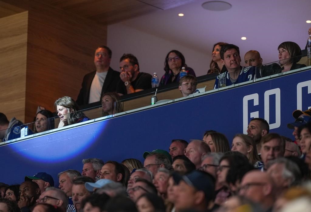 Alberta Premier Danielle Smith, front second left, and B.C. Premier David Eby, front second right, watch the Vancouver Canucks and Edmonton Oilers play Game 2 of an NHL hockey Stanley Cup second-round playoff series, in Vancouver, on Friday, May 10, 2024. Alberta's Infrastructure Minister Peter Guthrie says he also accepted free Edmonton Oilers playoff tickets, but he didn't break conflict-of-interest rules. THE CANADIAN PRESS/Darryl Dyck