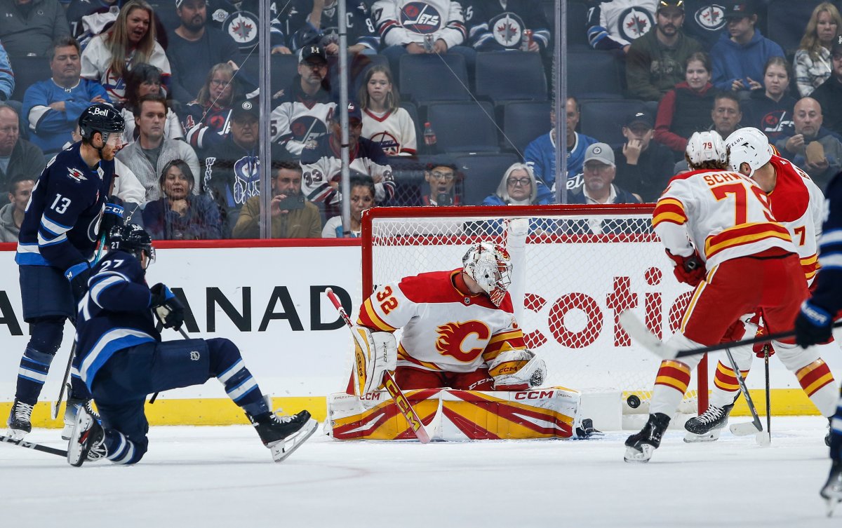 Winnipeg Jets' Nikolaj Ehlers (27) scores against Calgary Flames goaltender Dustin Wolf (32) during first period NHL pre-season action in Winnipeg on Wednesday, October 2, 2024. THE CANADIAN PRESS/John Woods