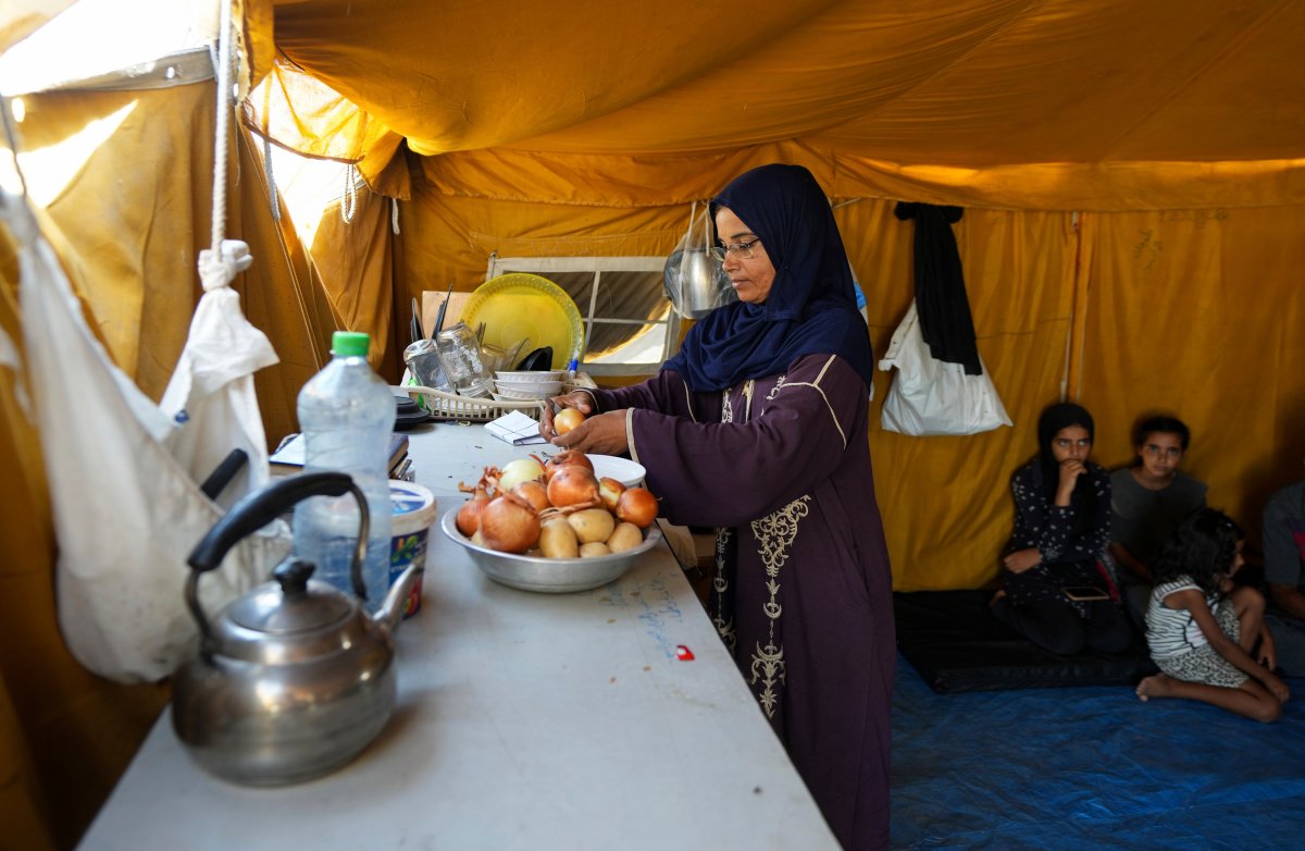 Majida Abu Jarad cooks in a tent camp, where she and her family now live after being displaced over five times since the start of the Israel-Hamas war, in Muwasi, Gaza Strip, Thursday, Sept. 12, 2024. (AP Photo/Abdel Kareem Hana)