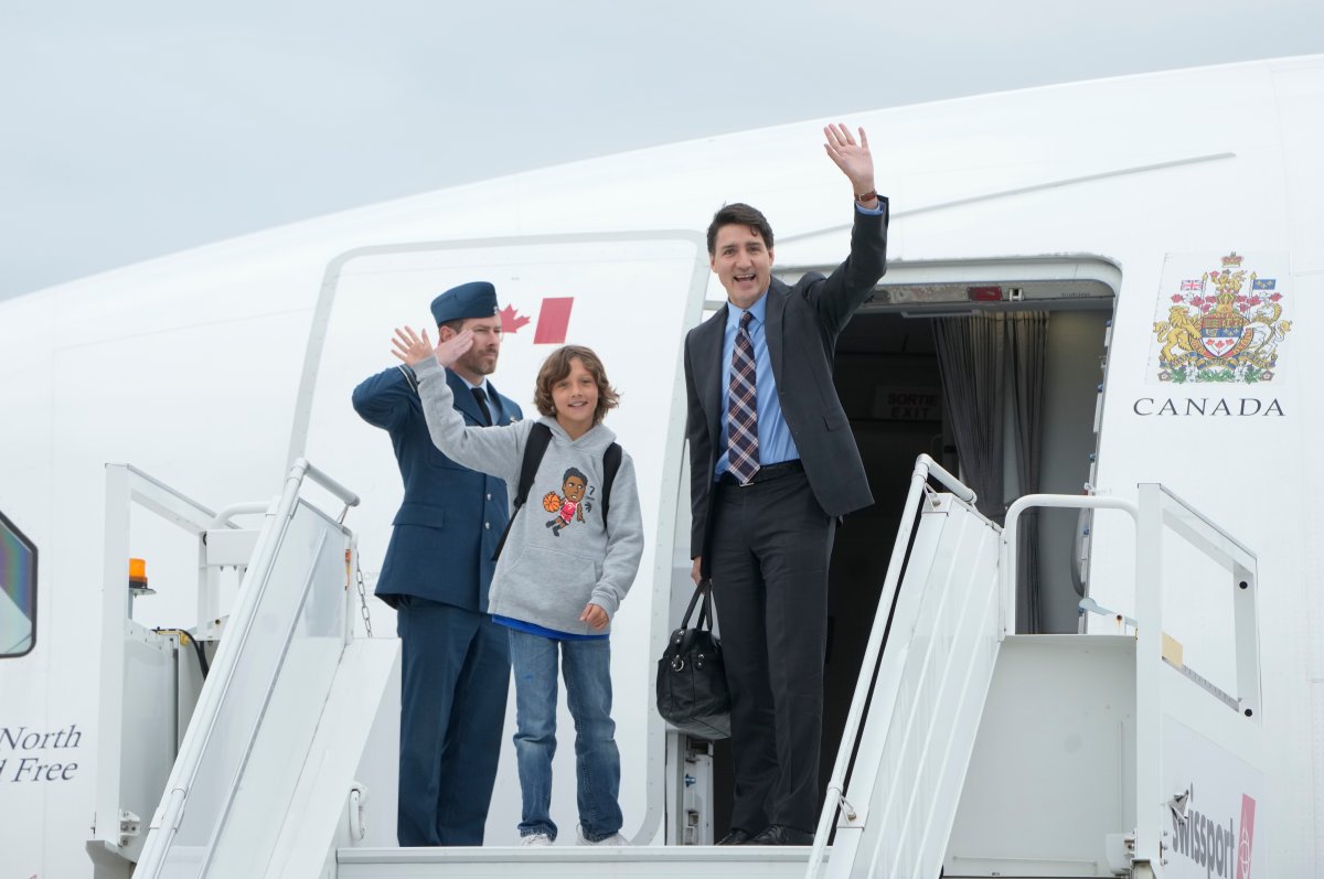 Prime Minister Justin Trudeau boards a government plane with his son Hadrien at the airport, Tuesday, Oct. 8, 2024 in Ottawa.