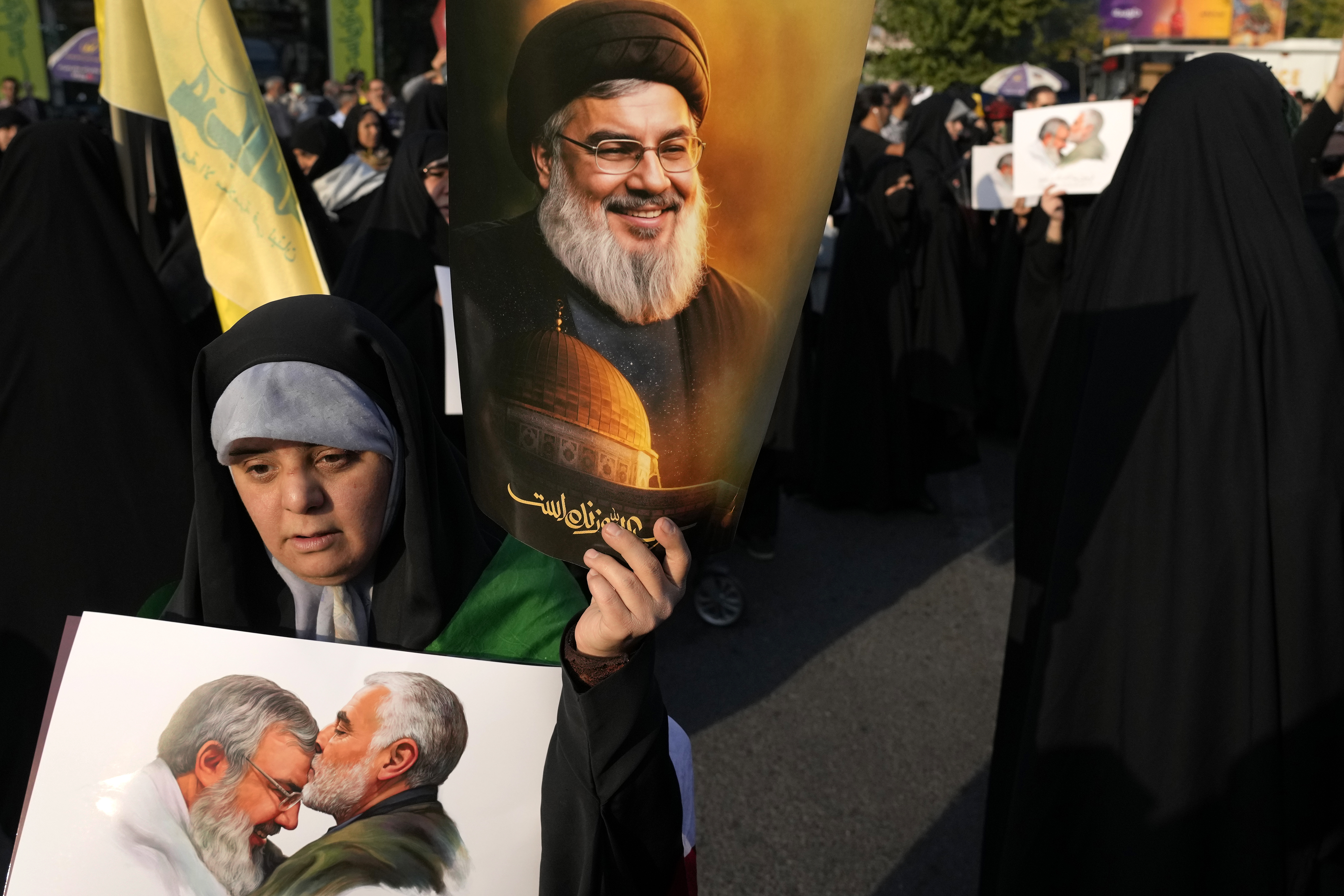 A demonstrator holds posters of slain Hezbollah leader Hassan Nasrallah in an anti-Israeli gathering at Felestin (Palestine) Square, Tehran, Iran, Oct. 8, 2024. (AP Photo/Vahid Salemi)