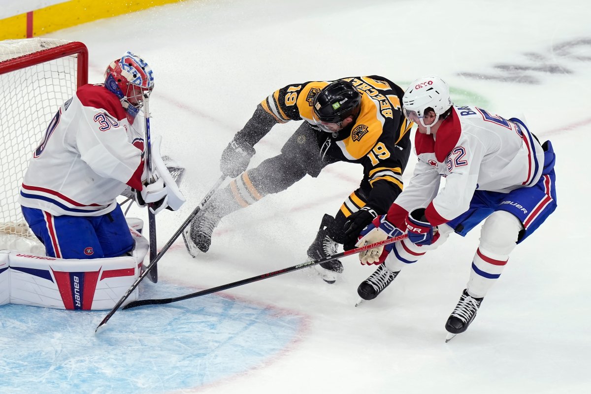 Montreal Canadiens' Cayden Primeau (30) blocks a shot by Boston Bruins' John Beecher (19) as Canadiens' Justin Barron (52) defends during the second period of an NHL hockey game, Thursday, Oct. 10, 2024, in Boston. 