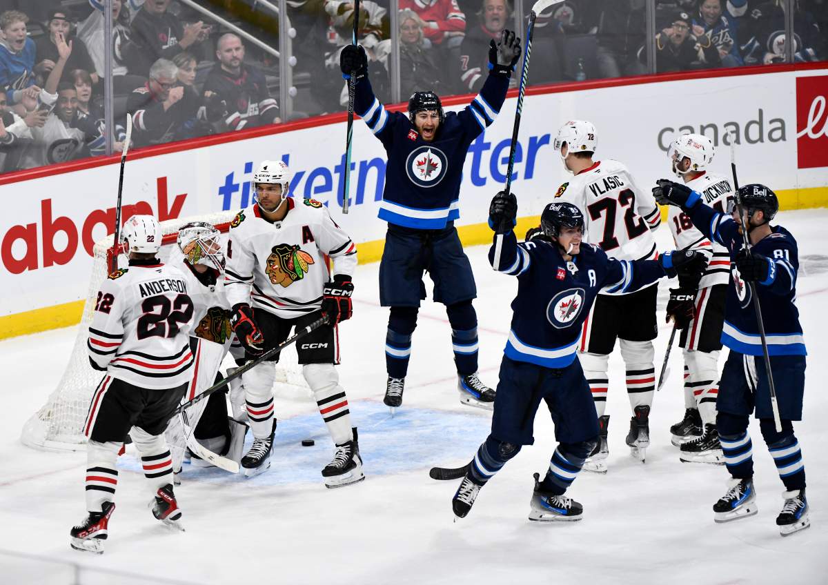 Winnipeg Jets' Mark Scheifele (55) celebrates his goal on Chicago Blackhawks goaltender Arvid Soderblom (40) with Gabriel Vilardi (13) and Kyle Connor (81) during the third period of their NHL hockey game in Winnipeg, Friday October 11, 2024. THE CANADIAN PRESS/Fred Greenslade.