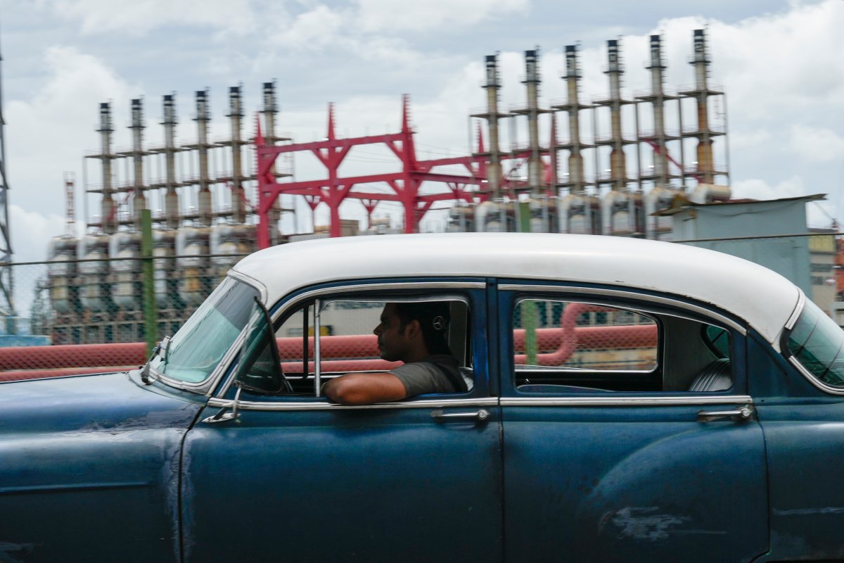 A person drives a classic American car past a floating generator that has not been producing electricity for days in Havana, Cuba, Friday, Oct. 18, 2024. (AP Photo/Ramon Espinosa).