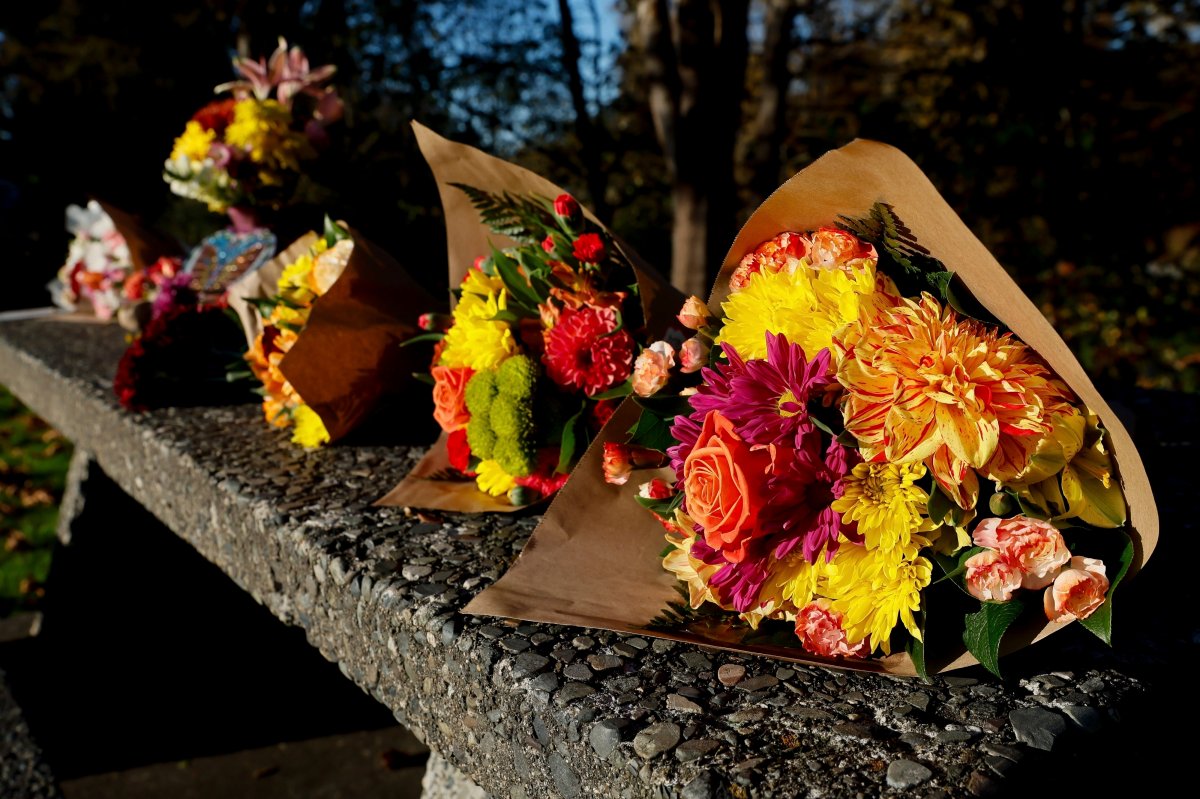 Bouquets of flowers line a stone picnic table at a roadside park as a small memorial to the victims of a mass shooting the day before in Fall City, Wash., Tuesday, Oct. 22, 2024.