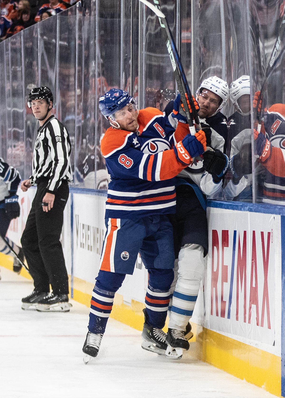 Winnipeg Jets' David Gustafsson (19) is checked by Edmonton Oilers' Drake Caggiula (8) during first period NHL preseason action in Edmonton, Sunday, Sept. 22, 2024.