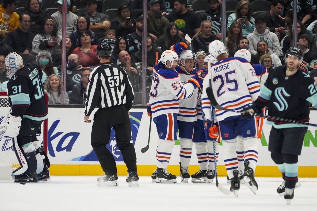 Edmonton Oilers forward Jeff Skinner (53) pats the head of defenceman Travis Dermott to celebrate Dermott's goal against Seattle Kraken goaltender Philipp Grubauer (31) during the second period of a preseason NHL hockey game Wednesday, Oct. 2, 2024, in Seattle.