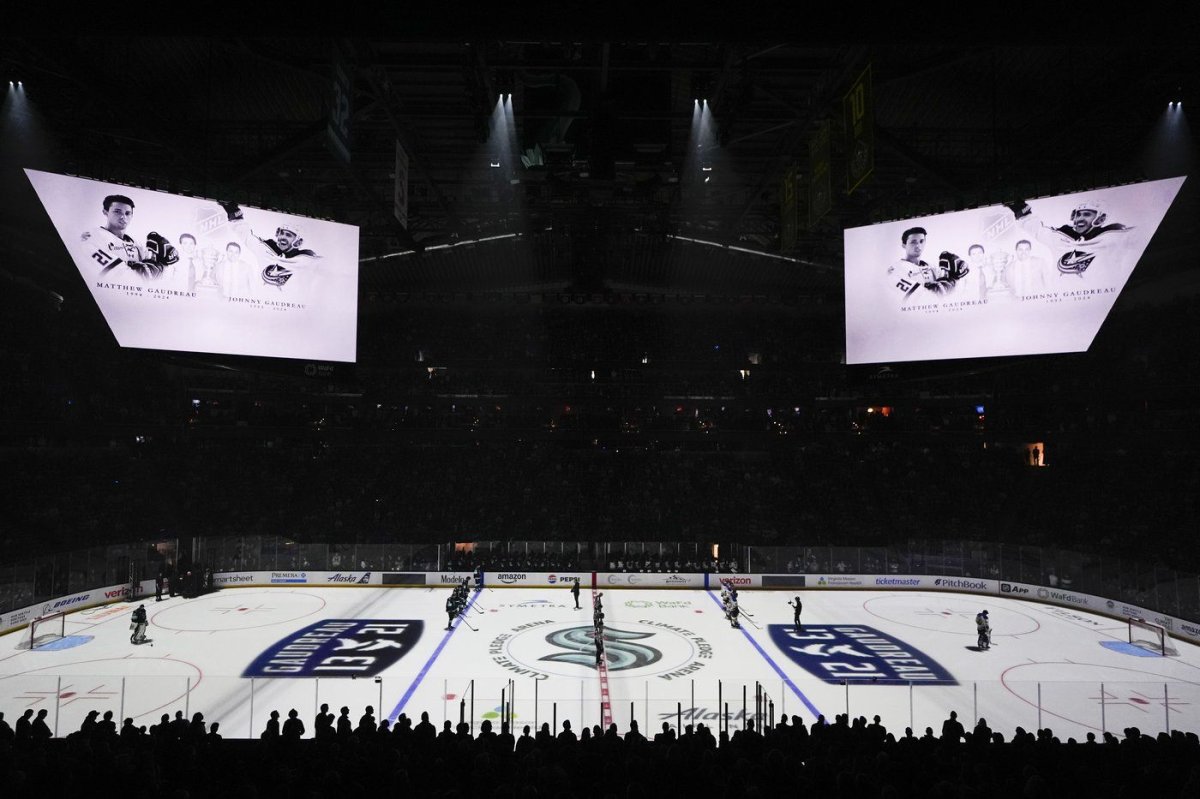 Seattle Kraken players stand for a moment of silence for Columbus Blue Jackets player Johnny Gaudreau and his brother Matthew Gaudreau, who were killed by a driver in New Jersey in August, before an NHL hockey game against the St. Louis Blues, Tuesday, Oct. 8, 2024, in Seattle.