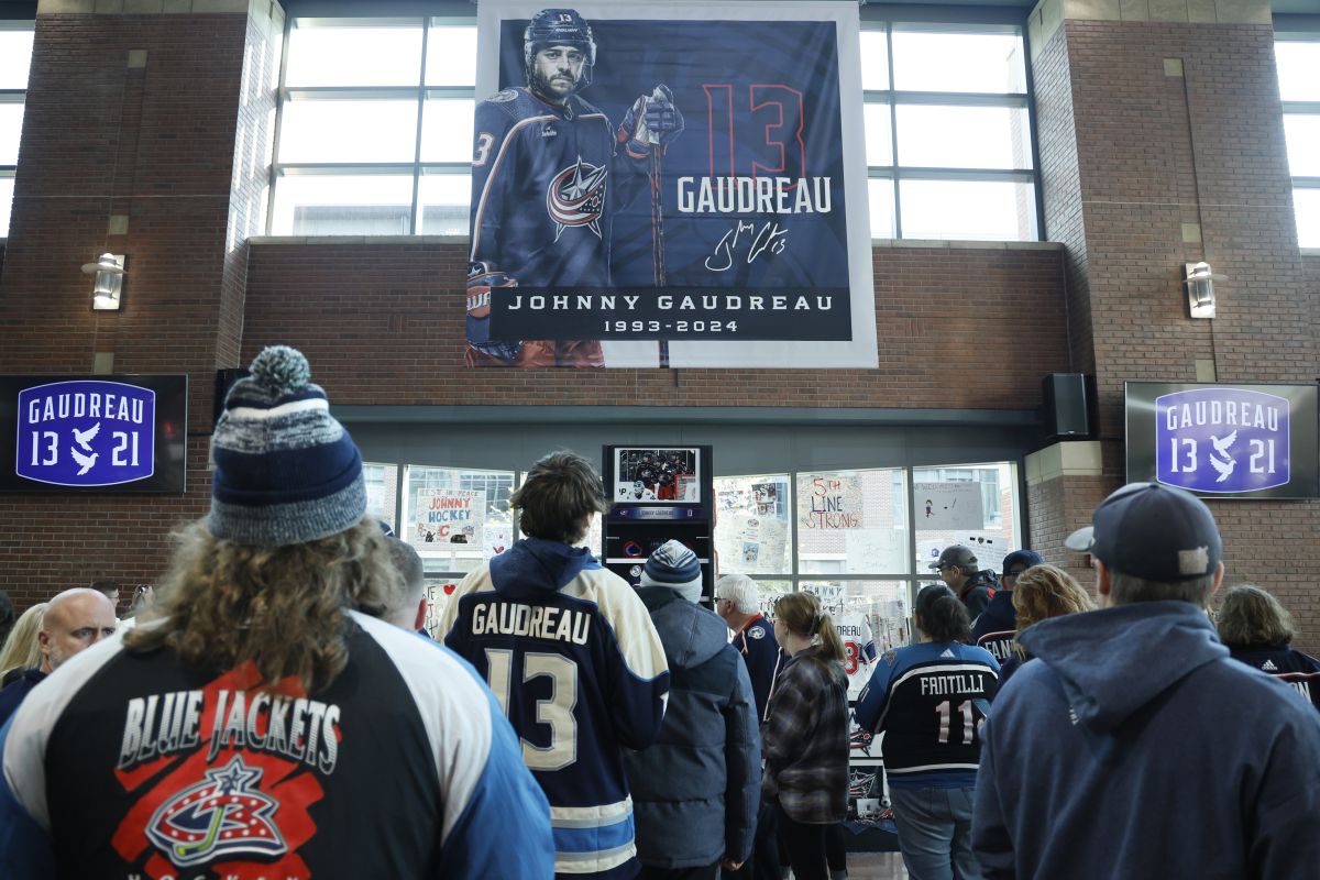 Fans look at a memorial of Columbus Blue Jackets' Johnny Gaudreau and his brother Matthew before the start of an NHL hockey game against the Florida Panthers. Tuesday, Oct. 15, 2024, in Columbus, Ohio.