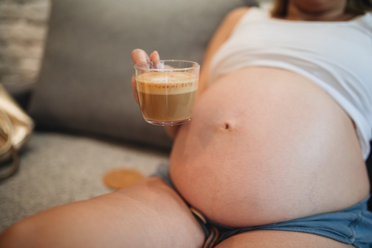 Pregnant woman doing her morning routine of drinking coffee.