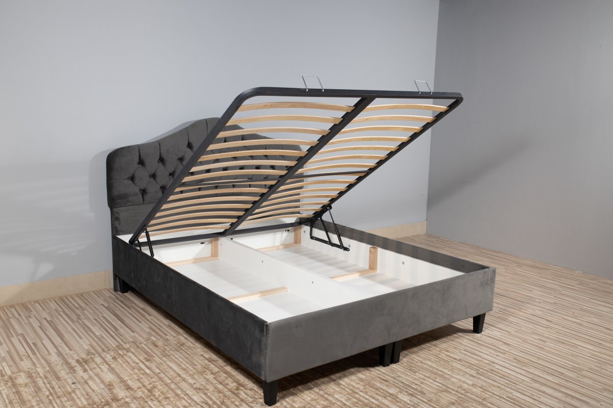 A bed with storage underneath. The mattress part is raised to show the storage area below.