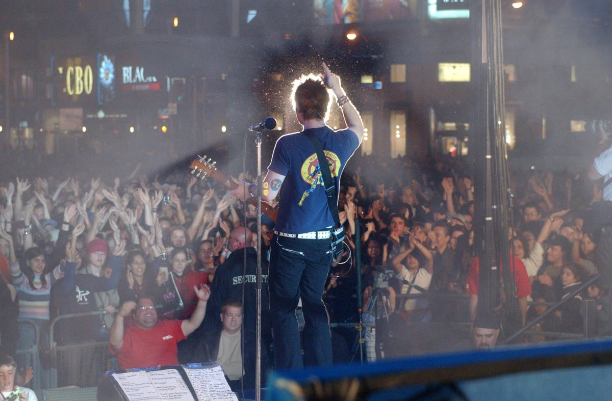 Greig Nori, lead singer of the rock band Treble Charger, cheers on the crowd as the band plays to over 50,000 people celebrating the new Dundas Square in Toronto at its grand opening evening , Friday May 30, 2003.