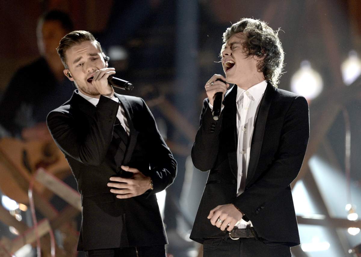 Liam Payne and Harry Styles singing on stage.