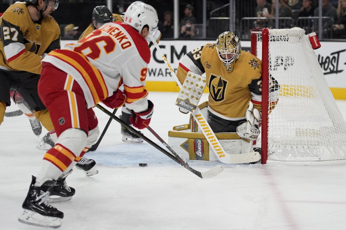 Calgary Flames left wing Andrei Kuzmenko (96) attempts a shot on Vegas Golden Knights goaltender Adin Hill (33) during the first period of an NHL hockey game Monday, Oct. 28, 2024, in Las Vegas.