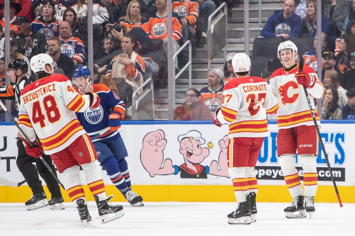 Calgary Flames Hunter Brzustewicz (48), Matt Coronato (27), and Sam Honzek (42) celebrate as Edmonton Oilers Noah Philp (48) skates off during second period NHL preseason action in Edmonton on Monday September 23, 2024.