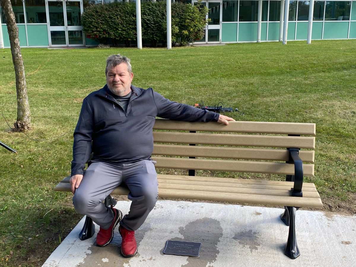 Mark Sheldon sitting on the bench in honour of his late sister outside the Carling Heights Optimist Community Centre in London.