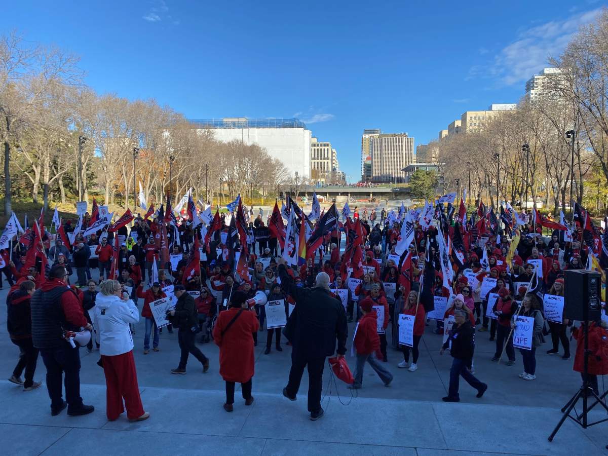 Protesters stand in front of the Alberta legislature on Oct. 24, 2024 to voice their opposition to the provincial government mandating the use of a dispute inquiry board in an ongoing labour dispute between school support workers and the Edmonton Public School Board.