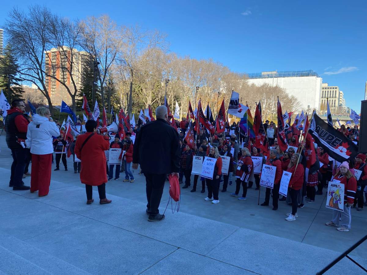 Protesters stand in front of the Alberta legislature on Oct. 24, 2024 to voice their opposition to the provincial government mandating the use of a dispute inquiry board in an ongoing labour dispute between school support workers and the Edmonton Public School Board.