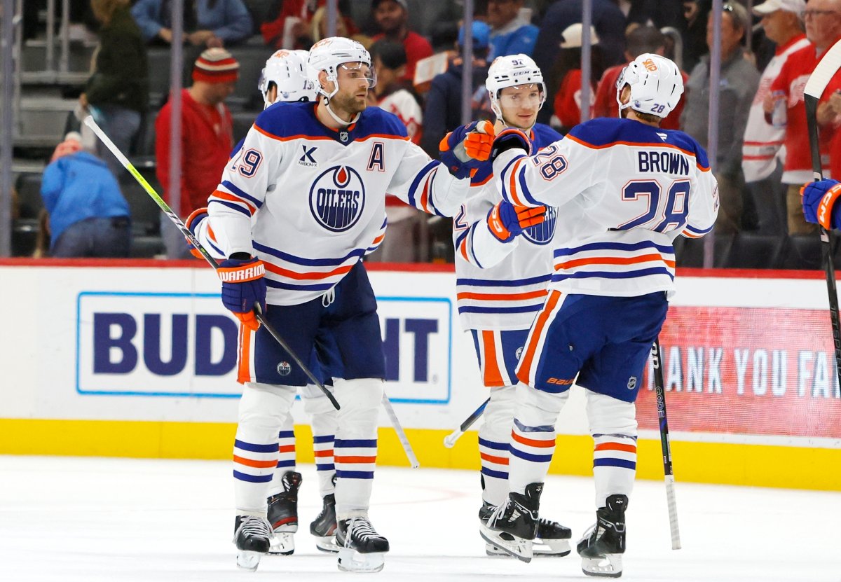 Edmonton Oilers center Leon Draisaitl (29) celebrates with right wing Vasily Podkolzin, center, and right wing Connor Brown (28) after scoring the winning goal against the Detroit Red Wings in overtime of an NHL hockey game Sunday, Oct. 27, 2024, in Detroit.