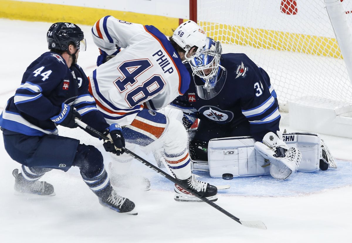 Winnipeg Jets goaltender Kaapo Kahkonen (34) saves the shot from Edmonton Oilers' Noah Philp (48) as Josh Morrissey (44) defends during first period NHL pre-season game action in Winnipeg on Wednesday, September 25, 2024.