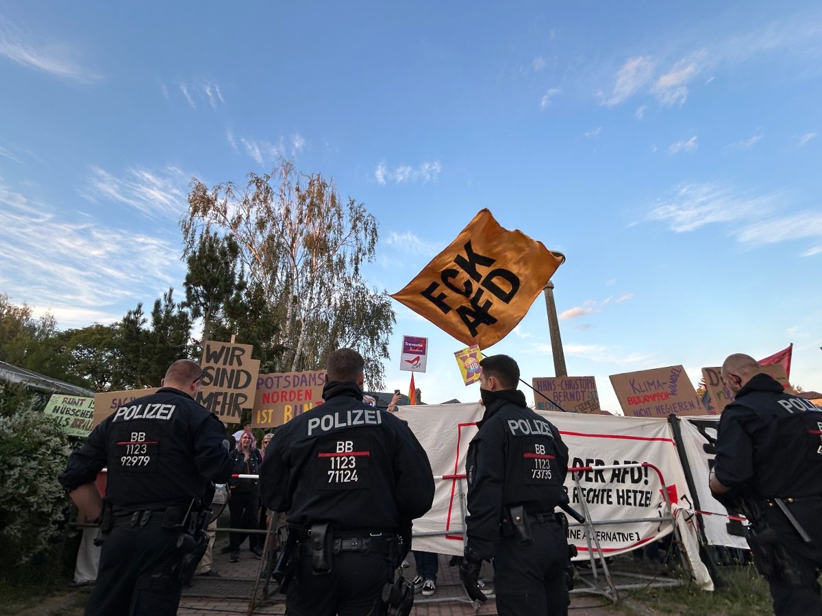 Protesters held back by police officers outside of the AfD headquarters.