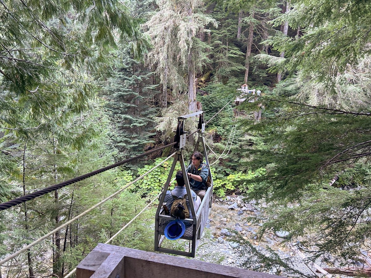 PNTA crew members use a cable car to cross the Chilliwack River in North Cascades National Park.