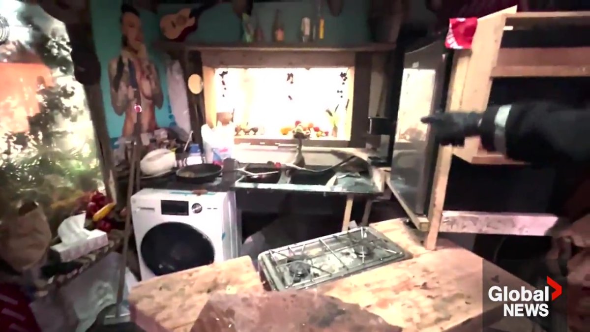 A working washing machine and mini fridge inside one of the huts at the encampment in southeast Edmonton.